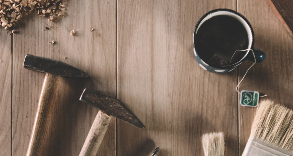 paint brush, coffee cup, hammer, wood shavings. Image: Milan Popovic on Unsplash.